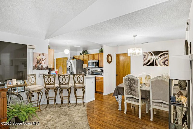 618 Americana Blvd NE, Palm Bay, FL 32907 - dining space featuring wood finished floors, a textured ceiling, and a chandelier