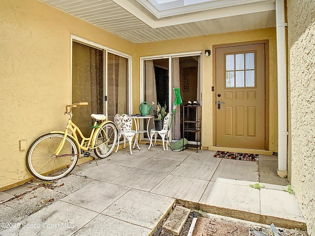 property entrance with a patio and stucco siding