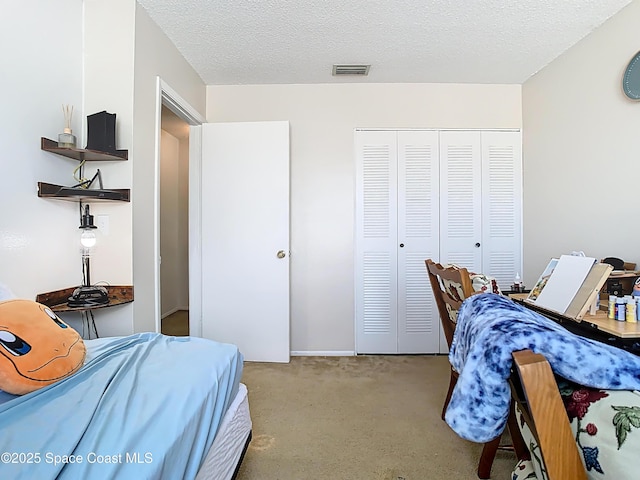 carpeted bedroom featuring visible vents, a closet, and a textured ceiling