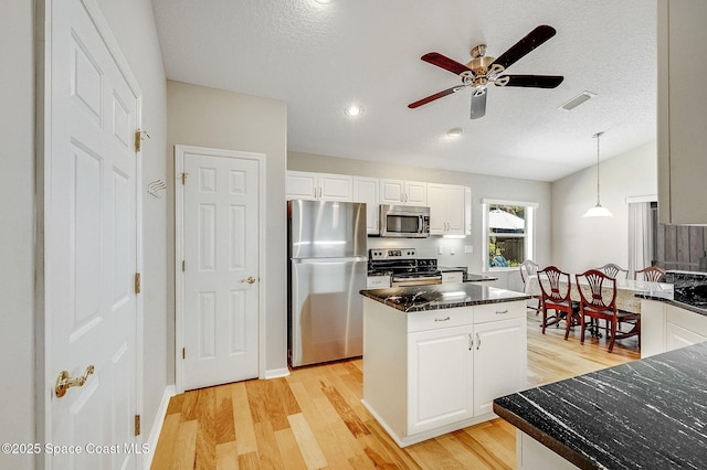 kitchen featuring light wood-style floors, a kitchen island, white cabinetry, and stainless steel appliances