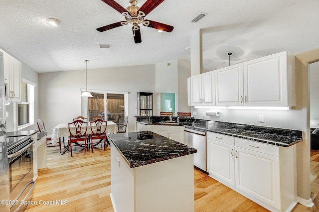 kitchen with visible vents, appliances with stainless steel finishes, a ceiling fan, light wood-style floors, and vaulted ceiling