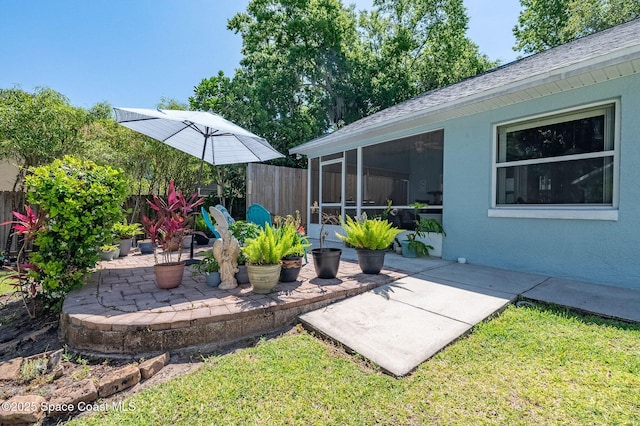 view of yard featuring a sunroom, a patio area, and fence