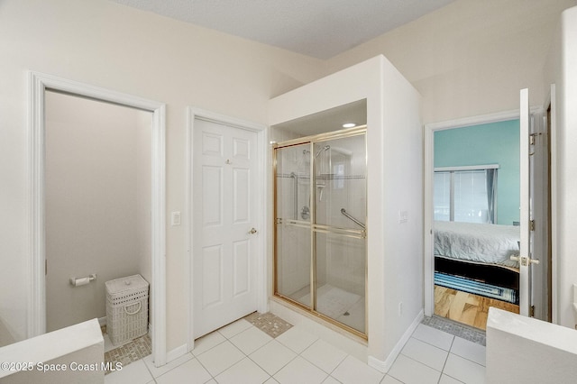 bathroom featuring a shower stall, tile patterned flooring, baseboards, and connected bathroom
