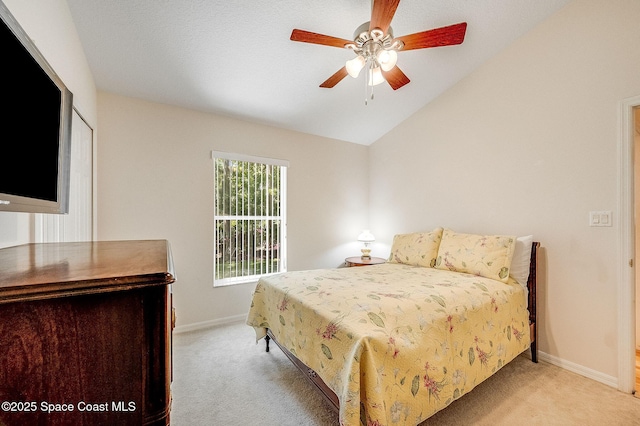 bedroom with light carpet, ceiling fan, baseboards, and vaulted ceiling