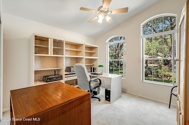 office area with a wealth of natural light, a ceiling fan, light colored carpet, and vaulted ceiling