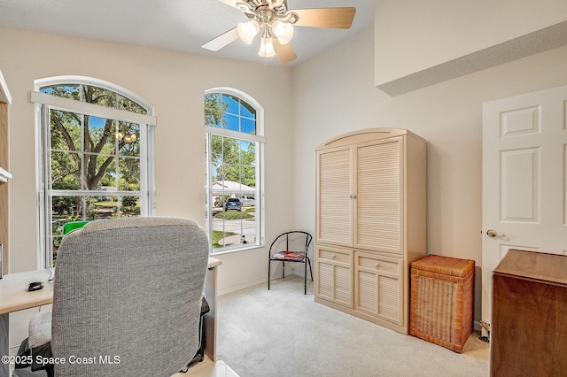 office featuring ceiling fan, light carpet, and baseboards