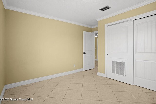 1845 Robalo Dr Unit 201D, Vero Beach, FL 32960 - unfurnished bedroom with baseboards, crown molding, visible vents, and a closet