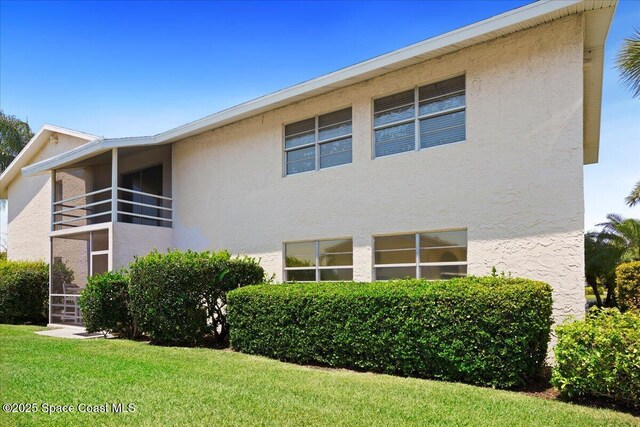 1845 Robalo Dr Unit 201D, Vero Beach, FL 32960 - exterior space with a lawn, a balcony, and stucco siding