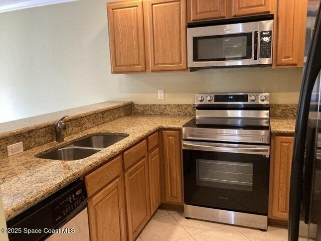 1845 Robalo Dr Unit 201D, Vero Beach, FL 32960 - kitchen featuring light stone countertops, stainless steel appliances, a sink, and light tile patterned floors