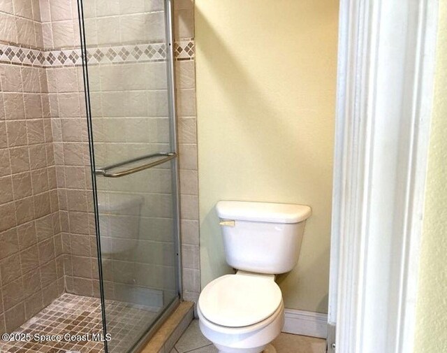 1845 Robalo Dr Unit 201D, Vero Beach, FL 32960 - bathroom with baseboards, toilet, tile patterned floors, and a stall shower