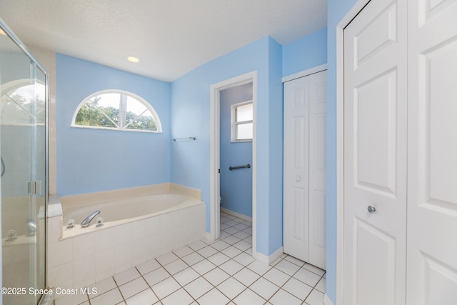 1872 Crane Creek Blvd, Melbourne, FL 32940 - bathroom featuring a closet, tile patterned flooring, a shower stall, and a garden tub