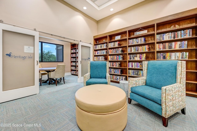 sitting room with recessed lighting, carpet floors, a towering ceiling, and a barn door