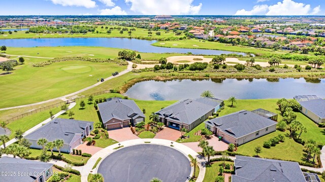 aerial view with a residential view, a water view, and view of golf course