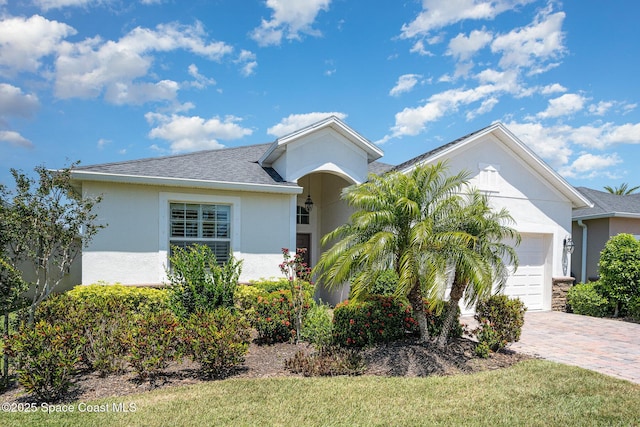 single story home with a garage, a shingled roof, driveway, and stucco siding
