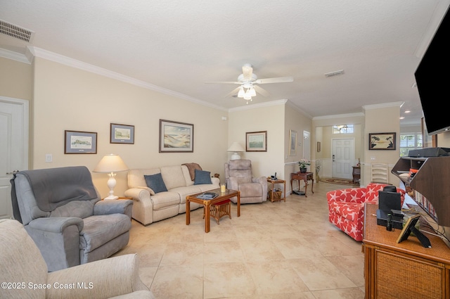 living area with visible vents, crown molding, and ceiling fan