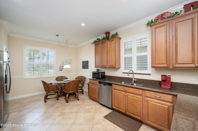 kitchen with brown cabinets, ornamental molding, a sink, baseboards, and appliances with stainless steel finishes