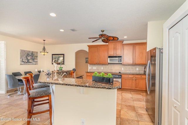 1472 Bent Palm Dr, Merritt Island, FL 32952 - kitchen featuring stainless steel appliances, ceiling fan, arched walkways, tasteful backsplash, and recessed lighting