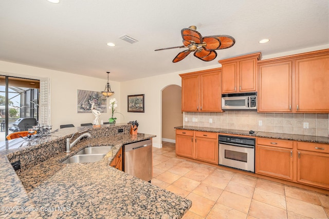 1472 Bent Palm Dr, Merritt Island, FL 32952 - kitchen with stainless steel appliances, a sink, arched walkways, a ceiling fan, and tasteful backsplash