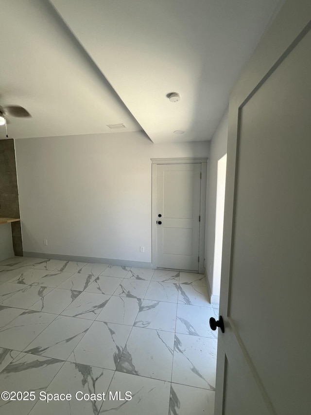 1279 Earl Dr, Merritt Island, FL 32952 - unfurnished room with marble finish floor, baseboards, and a ceiling fan
