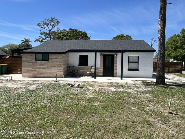 1279 Earl Dr, Merritt Island, FL 32952 - view of front of house featuring roof with shingles, stone siding, and fence
