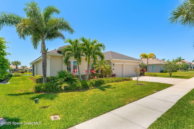 ranch-style house with a tiled roof, driveway, a front yard, an attached garage, and stucco siding