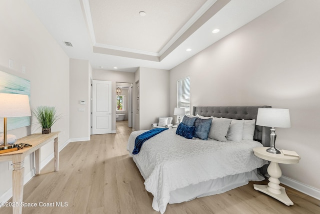 bedroom with visible vents, baseboards, a raised ceiling, light wood-style floors, and recessed lighting