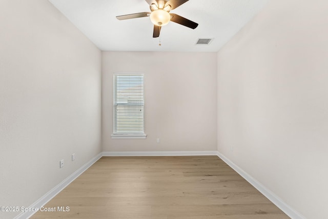 empty room featuring a ceiling fan, baseboards, visible vents, and light wood finished floors