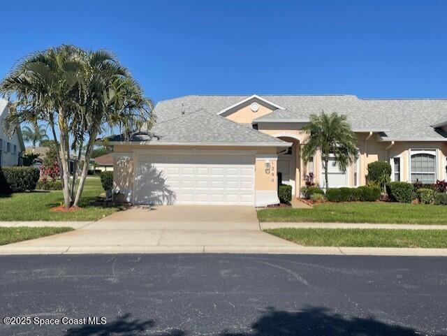 single story home featuring stucco siding, a front lawn, concrete driveway, and an attached garage