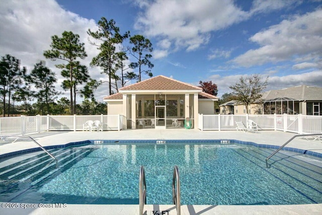 pool featuring fence, an outdoor structure, and a patio