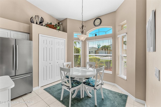 dining space with baseboards and light tile patterned floors