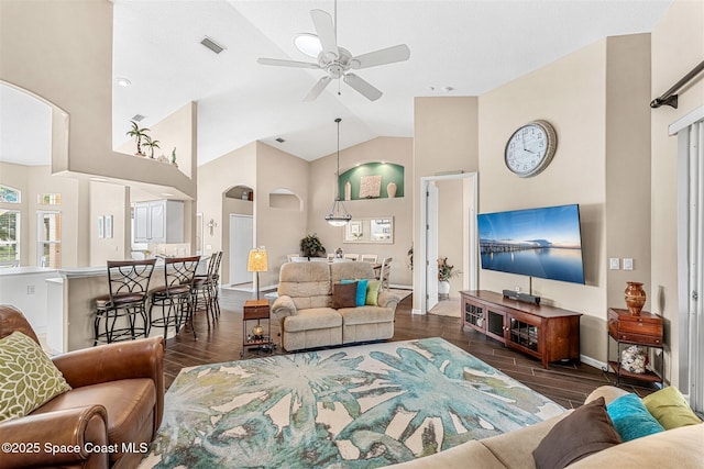 living area with wood finished floors, visible vents, a ceiling fan, and high vaulted ceiling