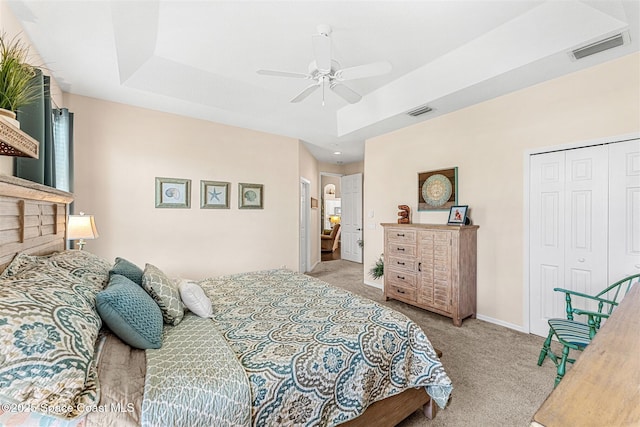 carpeted bedroom featuring a closet, visible vents, ceiling fan, and baseboards