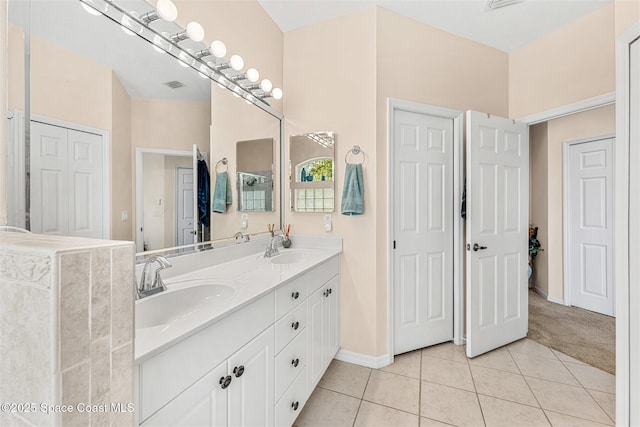 bathroom featuring double vanity, a sink, tile patterned floors, and visible vents