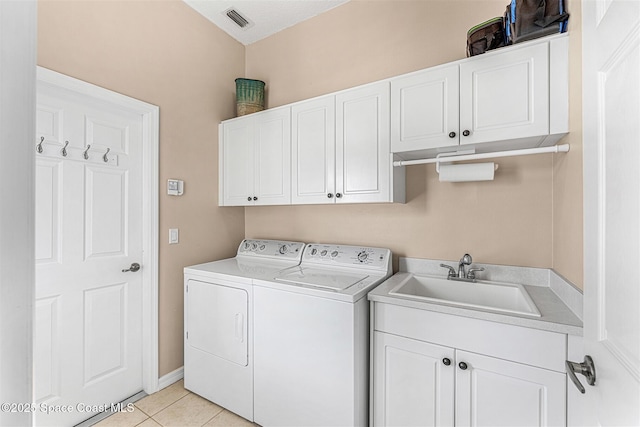 washroom featuring cabinet space, a sink, independent washer and dryer, light tile patterned floors, and visible vents