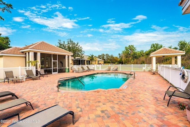 community pool featuring a sunroom, a gazebo, a patio area, and fence