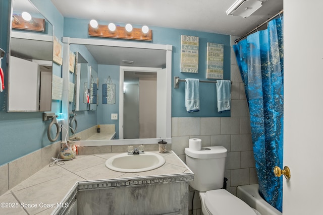 full bathroom with tile walls, vanity, and toilet