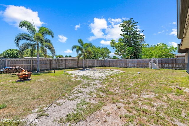 view of yard featuring a fenced backyard and an outdoor fire pit