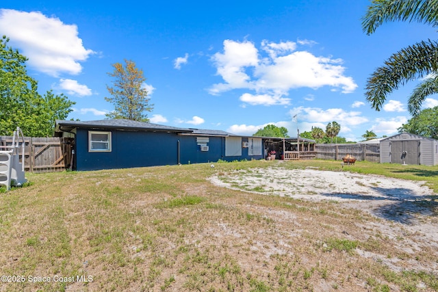 view of yard with a fenced backyard, an outdoor structure, and a storage shed