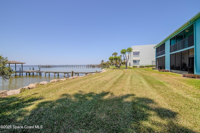 view of yard with a water view and a dock