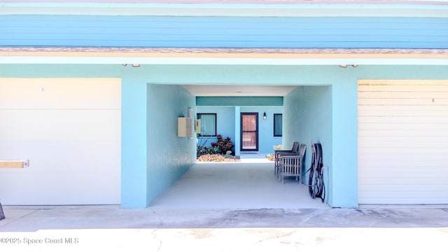 property entrance featuring stucco siding and a garage