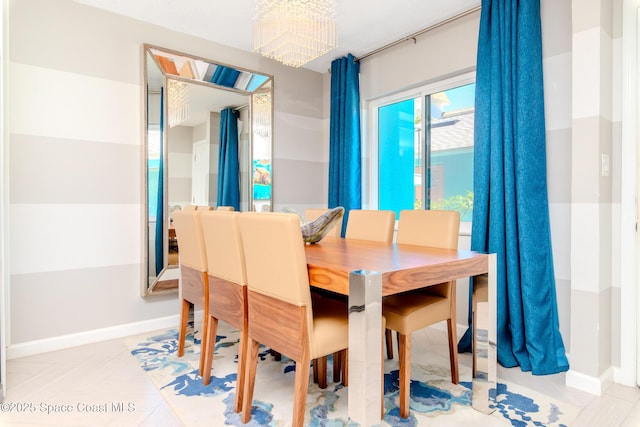 dining space with baseboards and an inviting chandelier