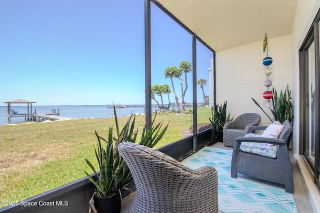sunroom / solarium featuring a water view