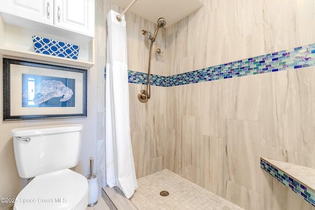 bathroom featuring toilet and tiled shower