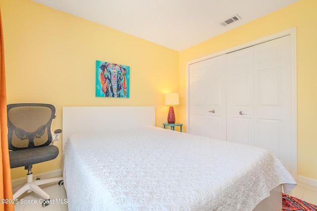 tiled bedroom featuring baseboards, visible vents, and a closet