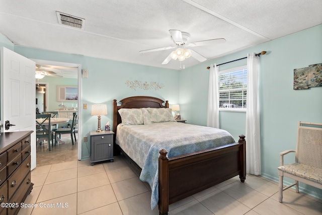 bedroom with visible vents, baseboards, ceiling fan, and light tile patterned floors
