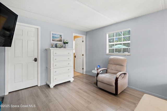 sitting room featuring baseboards and light wood finished floors