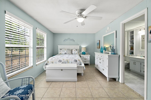 bedroom featuring a sink, ensuite bath, light tile patterned floors, and ceiling fan