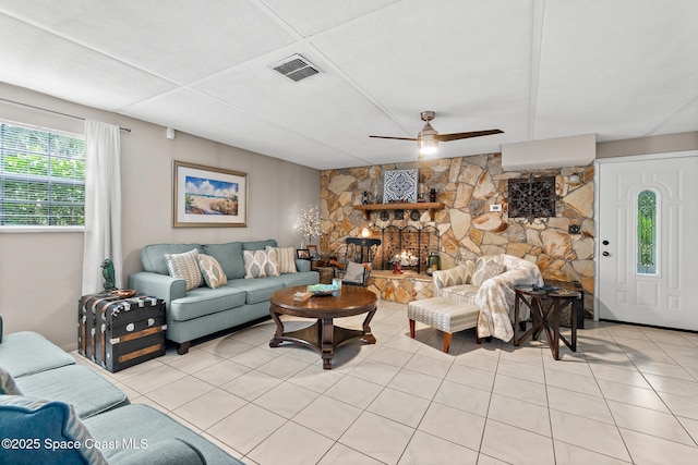 living room with a ceiling fan, visible vents, and light tile patterned floors