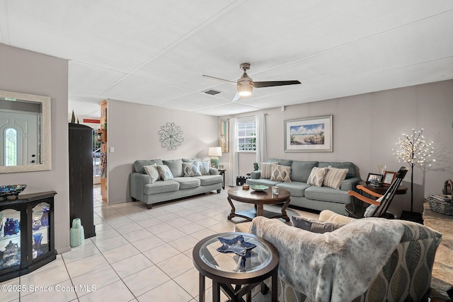 living area featuring light tile patterned floors, a ceiling fan, and visible vents