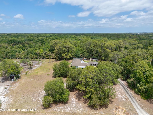 drone / aerial view featuring a wooded view
